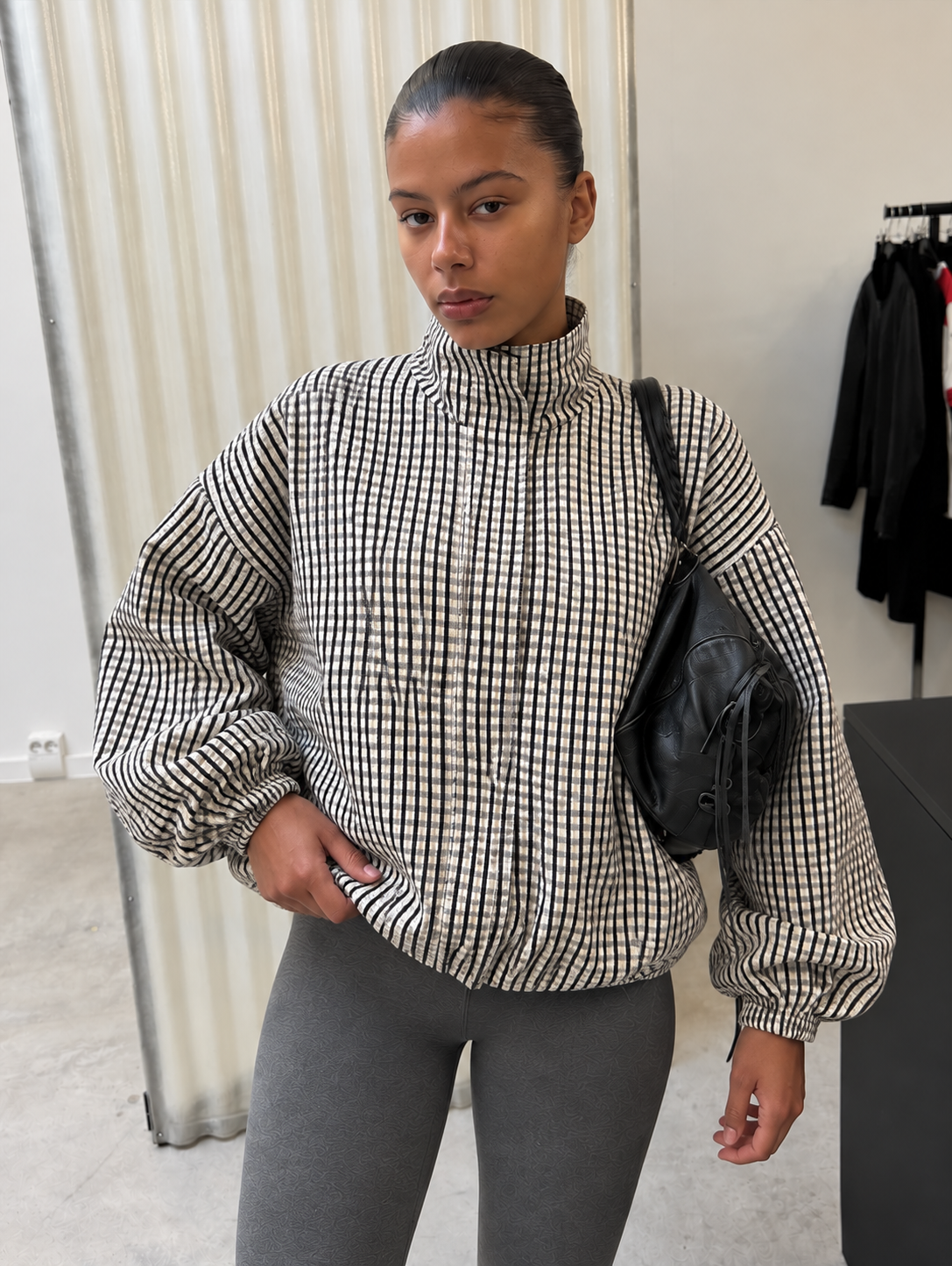 Oversized check jacket worn with grey trousers