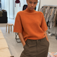 Pull orange col montant porté avec un pantalon large kaki