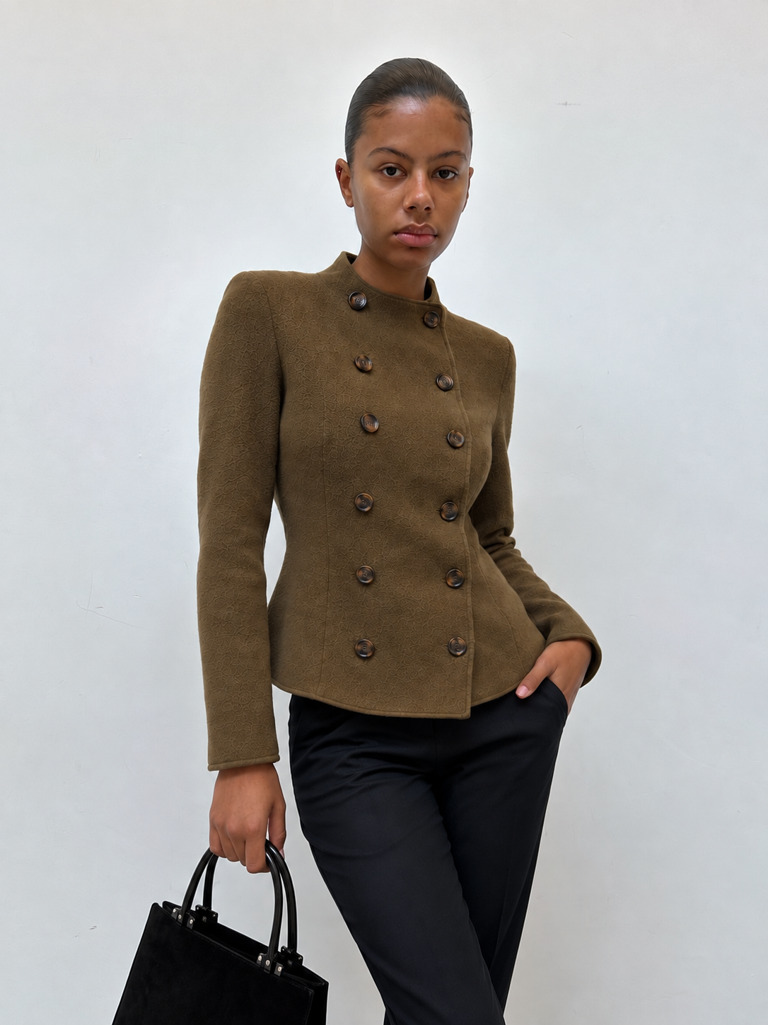 Veste cintrée kaki à double boutonnage portée avec un jean noir