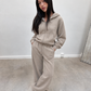 Ensemble jogging taupe porté, mains dans les poches