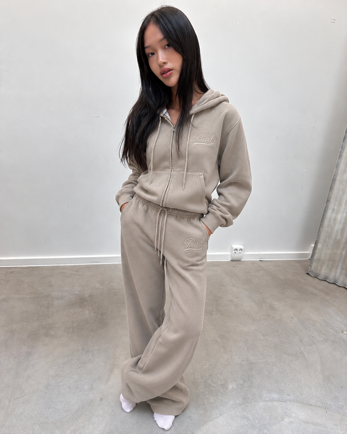 Ensemble jogging taupe porté, mains dans les poches