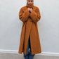 Manteau long camel à col montant porté avec un jean