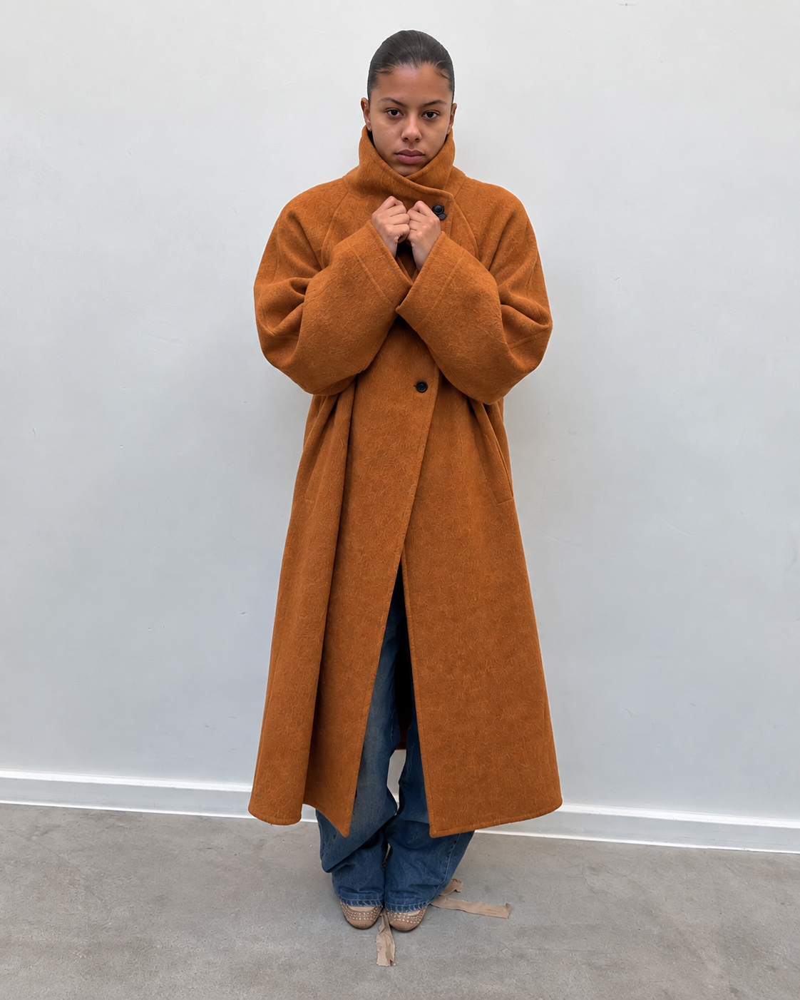 Manteau long camel à col montant porté avec un jean