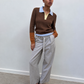 Pull col polo chocolat porté avec un pantalon gris