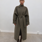 Manteau long kaki ceinturé, porté ouvert