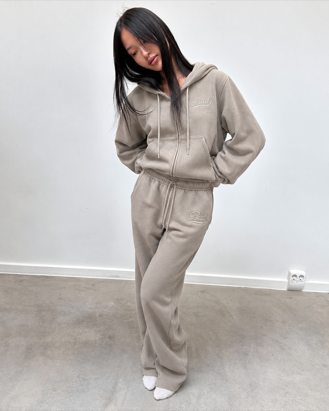 Ensemble jogging taupe, gilet zippé et pantalon large, porté de face