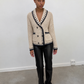 Cardigan en maille écrue porté avec un pantalon noir