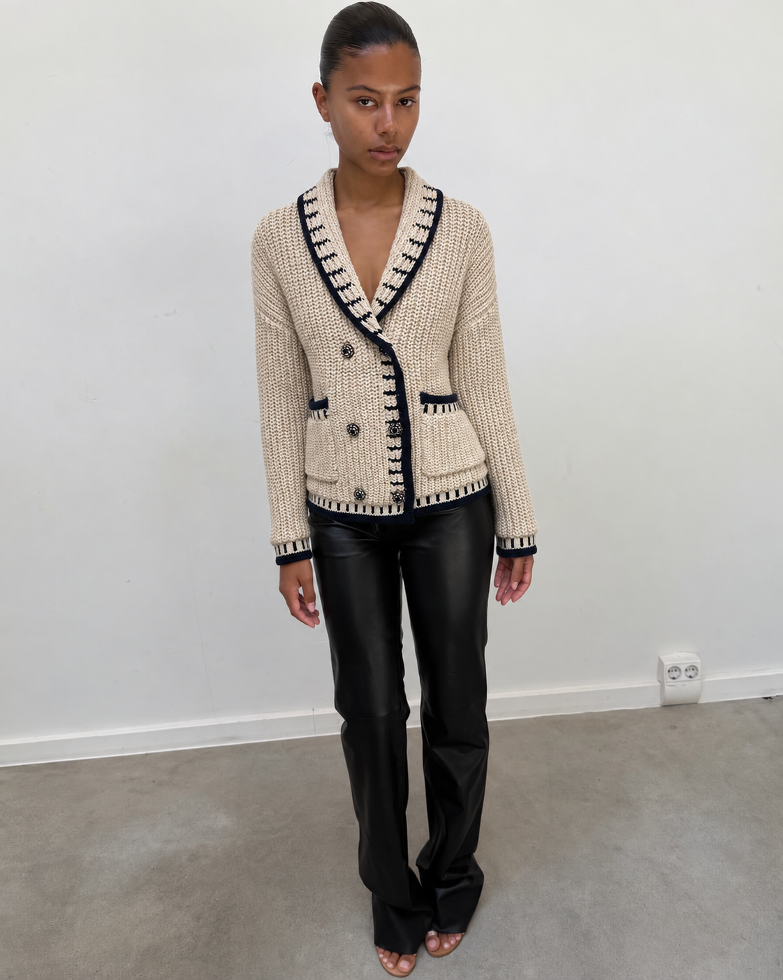 Cardigan en maille écrue porté avec un pantalon noir