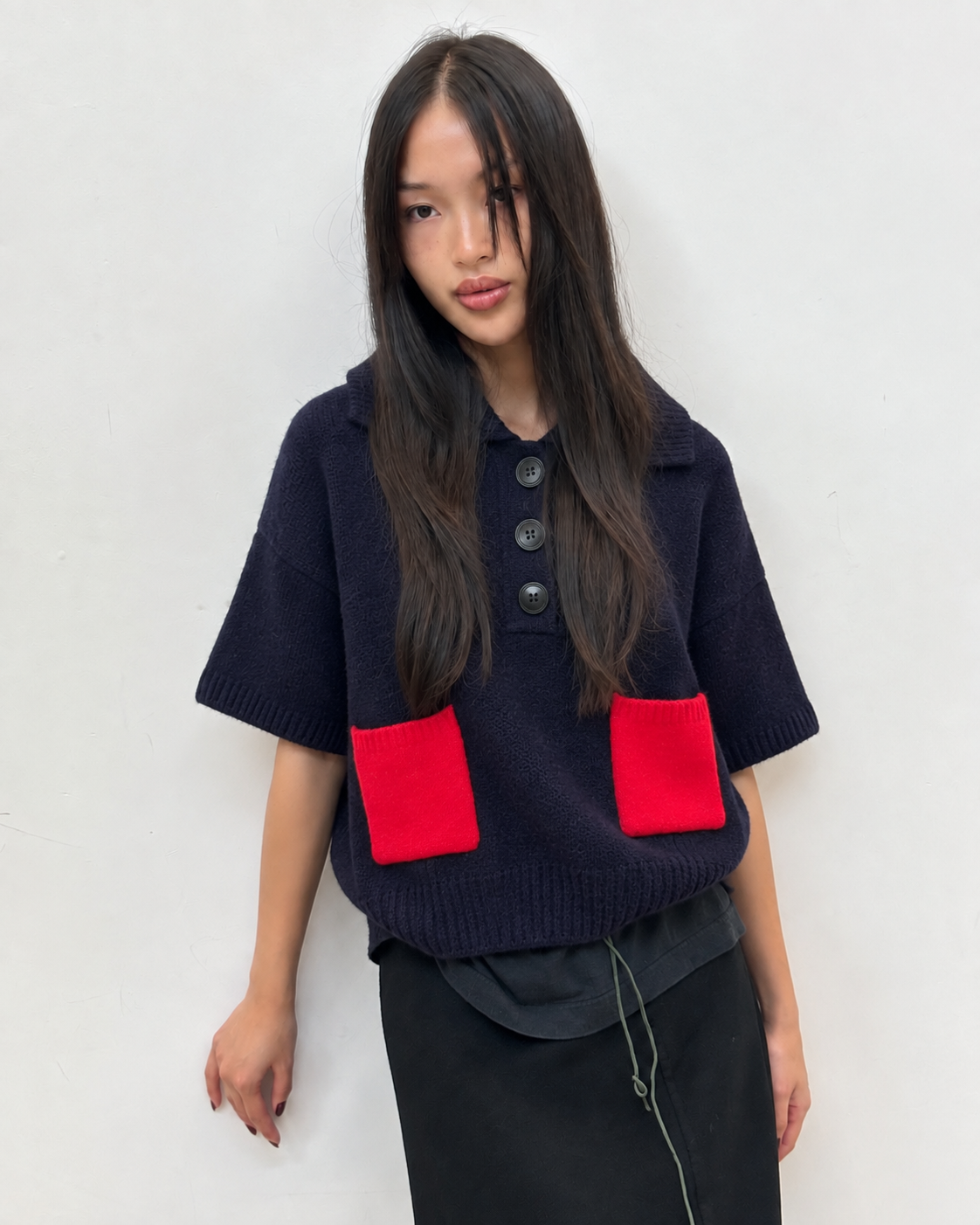 Polo en maille à poche contrastée, détail du col boutonné