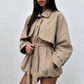 Trench court beige porté par une mannequin