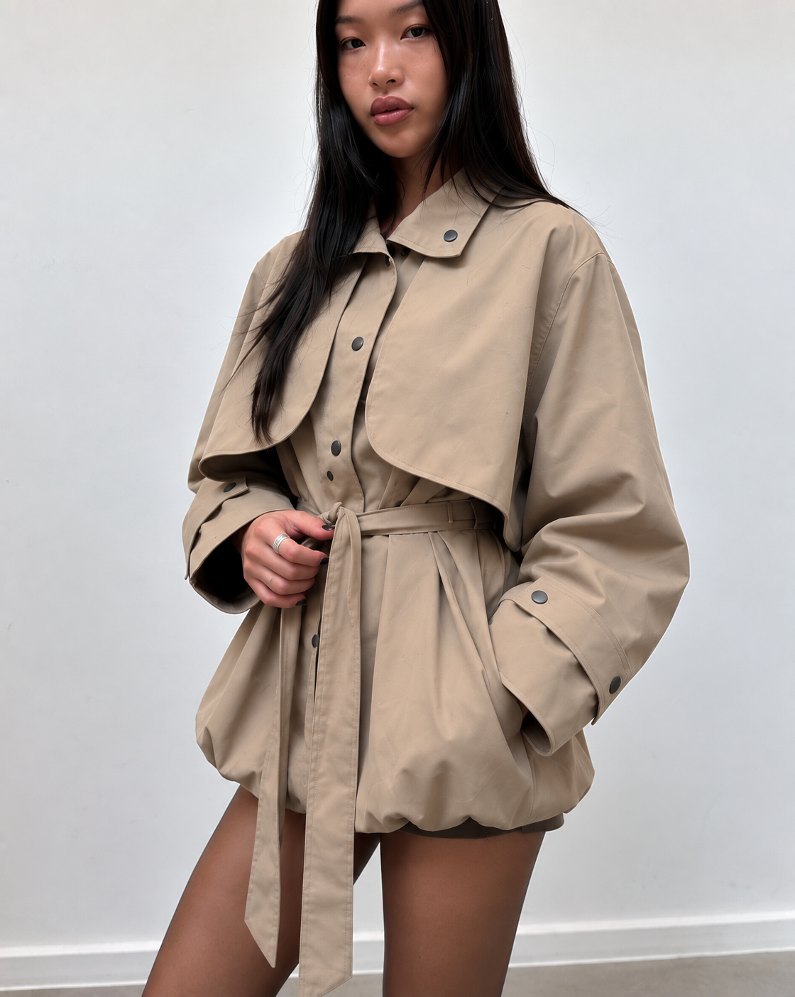 Trench court beige porté par une mannequin